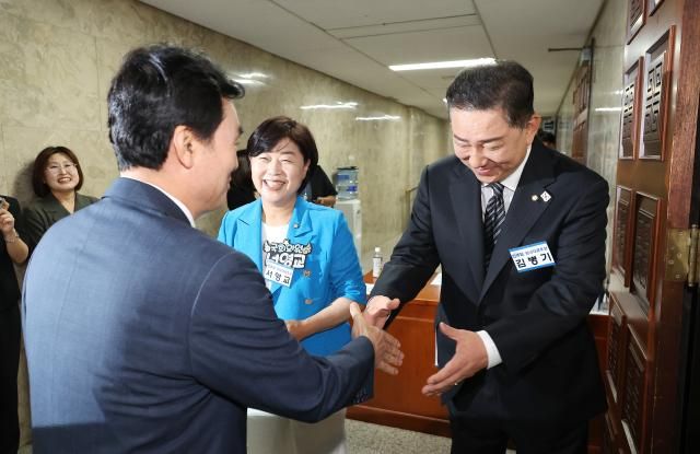 더불어민주당 원내대표 경선에 출마한 김병기 의원과 서영교 의원이 13일 서울 여의도 국회에서 열린 원내대표 선출 의원총회에 입장하는 의원들과 인사하고 있다 사진연합뉴스