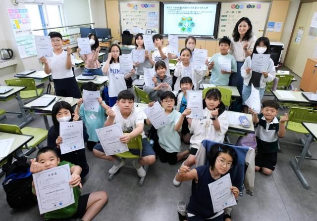 지난 12일 서울 관악구 봉현초에서 열린 WWF-PG 탄소중립·전 과정 평가 교육에 참가한 학생들과 선생님이 기념촬영을 하고 있다 사진한국PG