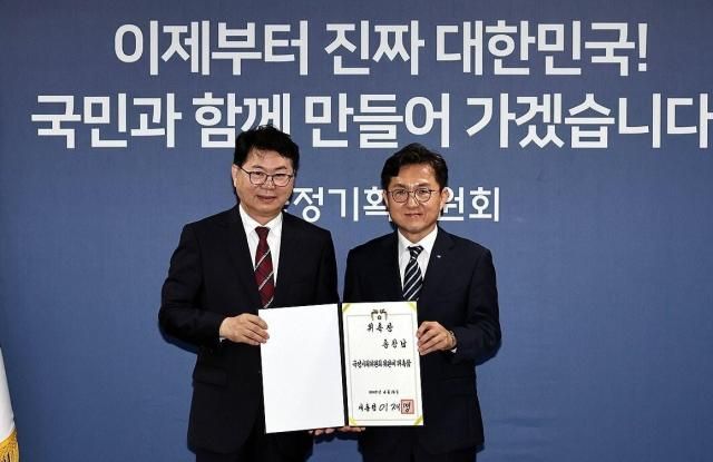 국정기획위원회 이한주 위원장왼쪽이 16일 서울 종로구 정부서울청사 창성동 별관에서 열린 출범식에서 사회2분과장을 맡은 홍창남 부산대 부총장에게 위촉장을 수여한 뒤 기념촬영을 하고 있다사진연합뉴스