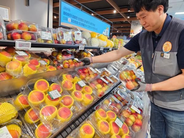 이마트 직원이 과일 매대를 채우고 있는 모습 사진이마트
