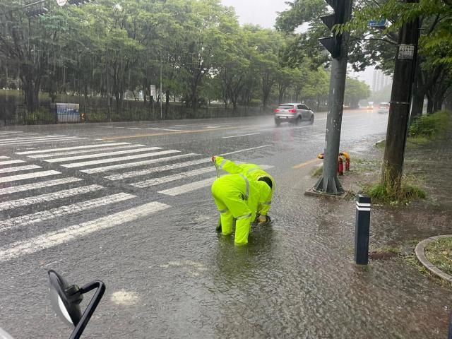 21일 광주 광산구 첨단2동에서 광산구 관계자들이 폭우로 이탈한 맨홀 뚜껑을 정비하고 있다 2025621 광주 광산구 제공 