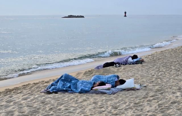 강원 동해안에 무더위가 계속되는 가운데 22일 새벽 강릉시 경포해변 백사장에서 시민들이 이불을 덮고 잠을 자고 있다 강릉은 최근 이틀 연속 열대야가 발생한 바 있다 사진연합뉴스