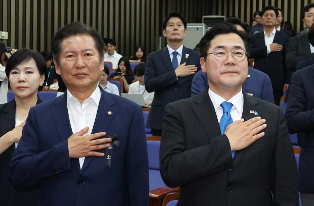 더불어민주당 당대표 후보인 정청래왼쪽·박찬대 의원이 24일 서울 여의도 국회에서 열린 의원총회에서 국기에 경례하고 있다 사진연합뉴스