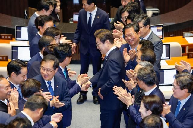 이재명 대통령이 26일 추가경정예산 시정연설을 하기 위해 국회 본회의장로 들어서며 여당 의원들과 악수하고 있다 사진연합뉴스