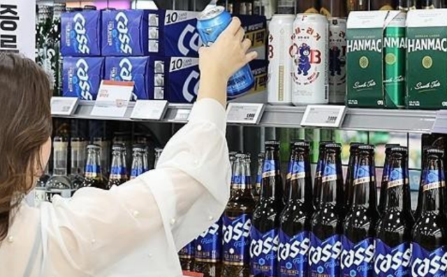 마트에 진열된 오비맥주 제품들을 한 시민이 살펴보고 있다 사진연합뉴스