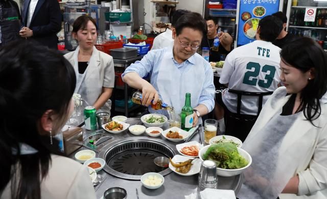 이재명 대통령이 11일 저녁 서울 광화문 인근 한식당에서 시민들과 식사 중 술을 따르고 있다 이 대통령은 식당을 찾기 전 SNS에 식사 계획을 알리며 민생회복 소비쿠폰 정책이 내수 진작과 지역경제 활성화에 활력을 불어넣길 기대한다고 밝혔다 사진연합뉴스