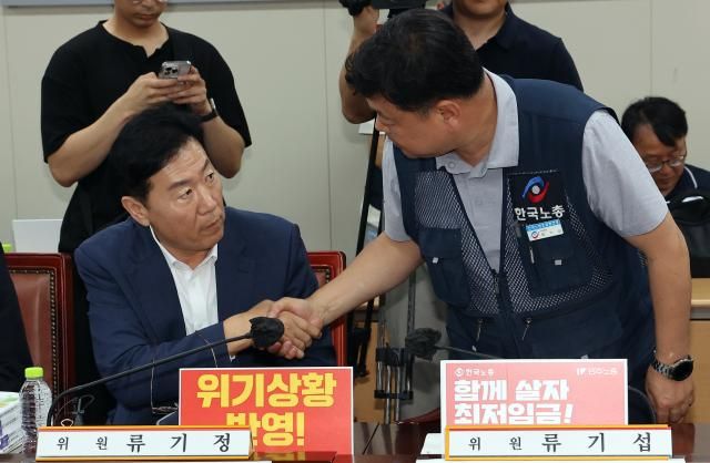 최저임금위원회 사용자위원인 류기정 한국경영자총협회 전무왼쪽와 근로자위원 류기섭 한국노총 사무총장이 1일 정부세종청사에서 열린 최저임금위원회 제8차 전원회의에 입장하며 악수를 나누고 있다 사진연합뉴스
