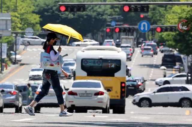 전국 대부분 지역에 폭염 특보가 발효된 3일 광주 서구 치평동에서 한 시민이 강렬한 햇빛에 달구어져 아지랑이가 피어오르는 도로를 걷고 있다 202573 사진연합뉴스 