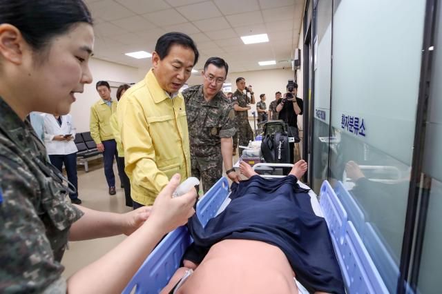 국방부차관이 의무사 소속 간호장교로부터 냉각시트를 활용한 온열손상 환자 초기대응에 관해 설명을 듣고 있다 사진국방부