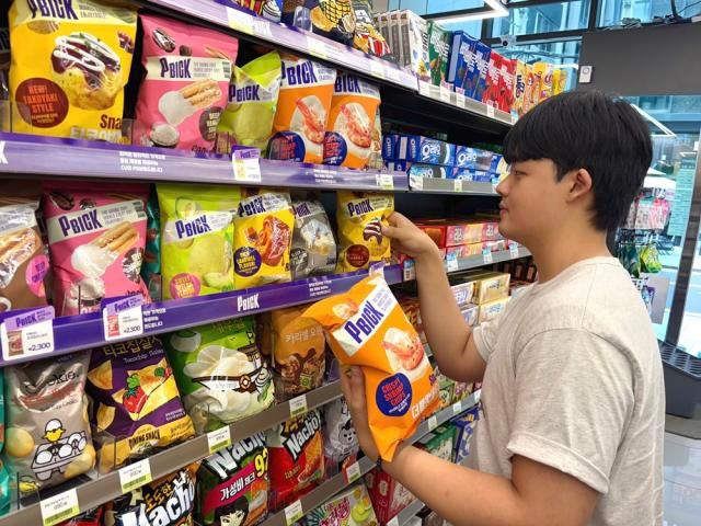 CU 한 매장에서 고객이 CU의 신규 자체브랜드PB인 피빅 제품을 고르고 있다 사진BGF리테일