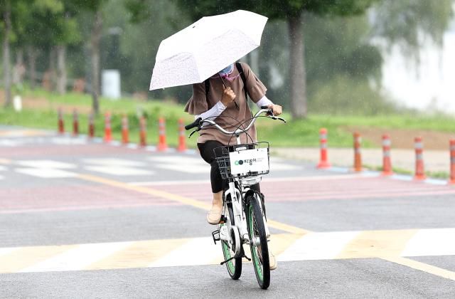 갑자기 소나기가 내린 21일 서울 영등포구 여의도한강공원에서 한 시민이 우산을 쓰고 이동하고 있다 2025721 사진연합뉴스 