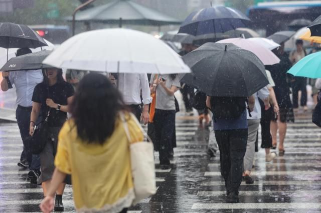 비가 내린 13일 서울 종로구 광화문 네거리에서 우산을 쓴 시민들이 길을 건너고 있다 사진연합뉴스