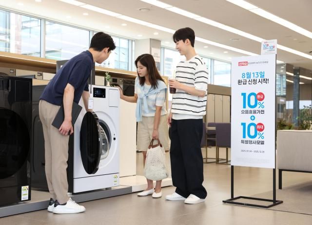 삼성전자 모델이 에너지 소비효율 1등급의 세탁건조기와 에어컨 제품의 설명을 듣고 있다 사진삼성전자