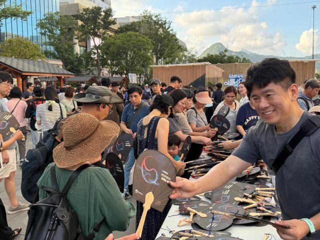 국민 임명식 관계자가 시민들에게 부채를 나눠주고 있다사진송승현 기자