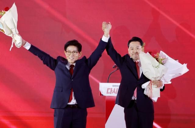 22일 충북 청주시 흥덕구 청주오스코에서 열린 국민의힘 제6차 전당대회에서 결선에 진출한 김문수 장동혁 당 대표 후보가 꽃다발을 건내 받은 뒤 손을 들어올리고 있다 사진연합뉴스