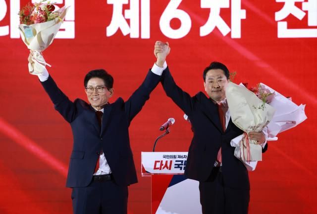 김문수 장동혁 당대표 국민의힘 후보가 지난 22일 충북 청주시 흥덕구 청주오스코에서 열린 국민의힘 제6차 전당대회에서 결선에 진출한 꽃다발을 받은 뒤 맞잡은 손을 들어 올리고 있다 사진연합뉴스