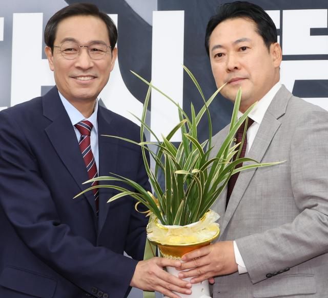 우상호 대통령실 정무수석이 27일 서울 여의도 국회에서 국민의힘 장동혁 신임 대표를 예방해 이재명 대통령이 보낸 축하난을 전달하고 있다사진연합뉴스