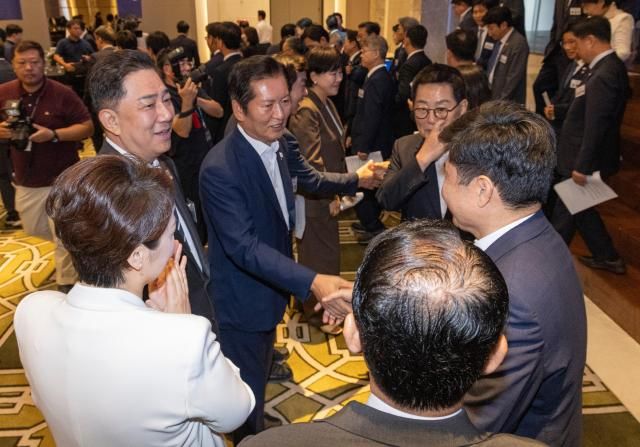 더불어민주당 정청래 대표와 김병기 원내대표가 29일 인천시 중구 파라다이스시티 컨벤션에서 열린 2025 정기국회 더불어민주당 의원단 워크숍에서 결의문을 채택한 뒤 동료 의원들과 악수하고 있다 사진연합뉴스