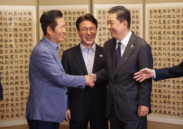 더불어민주당 정청래 대표와 김병기 원내대표가 14일 서울 종로구 총리 공관에서 열린 당·정·대더불어민주당·정부·대통령실 고위급 만찬회동에서 만나 밝은 표정으로 악수하고 있다 가운데는 김민석 국무총리 사진연합뉴스