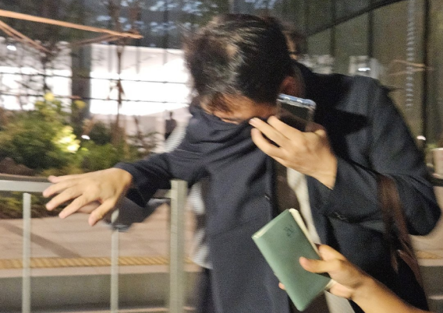 김건희 여사 오빠인 김진우씨가 지난 7월 28일 김 여사 관련 의혹들을 수사하는 민중기 특별검사팀 사무실이 위치한 서울 종로구 KT광화문빌딩에서 조사를 마친 뒤 얼굴을 가린 채 사무실을 나서고 있다 사진연합뉴스］