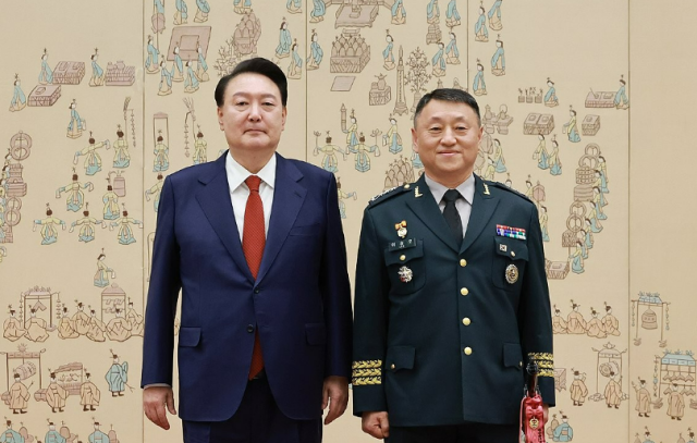 윤석열 전 대통령이 지난해 5월 서울 용산 대통령실 청사에서 열린 중장 진급·보직 신고 및 삼정검 수치 수여식에서 이승오 합동참모본부합참 작전본부장의 삼정검에 수치를 달아준 뒤 기념촬영을 하고 있다 사진연합뉴스