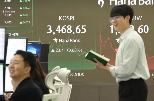 22일 서울 중구 하나은행 딜링룸에서 딜러들이 대화하고 있다. [사진=연합뉴스]