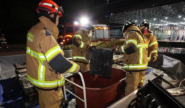 지난 27일 밤 대전 유성구 국가정보자원관리원 화재 현장에서 소방대원이 소화수조에 불에 탄 리튬이온 배터리를 옮기고 있다 사진연합뉴스