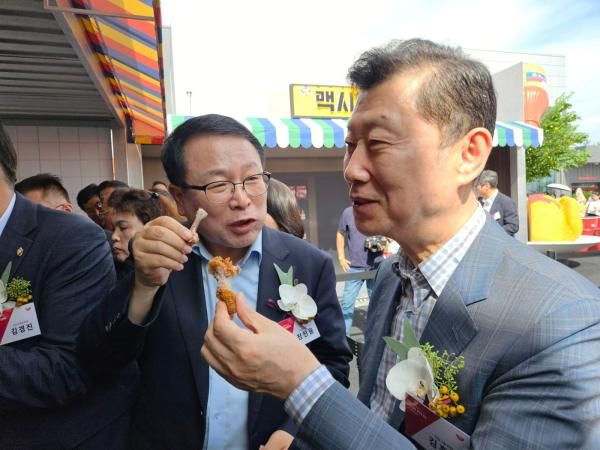 김홍국 하림그룹 회장이 지난 26일 전북 익산에서 열린 NS푸드페스타에서 정헌율 익산시장왼쪽과 함께 맥시칸 치킨을 맛보고 있다 사진홍승완 기자