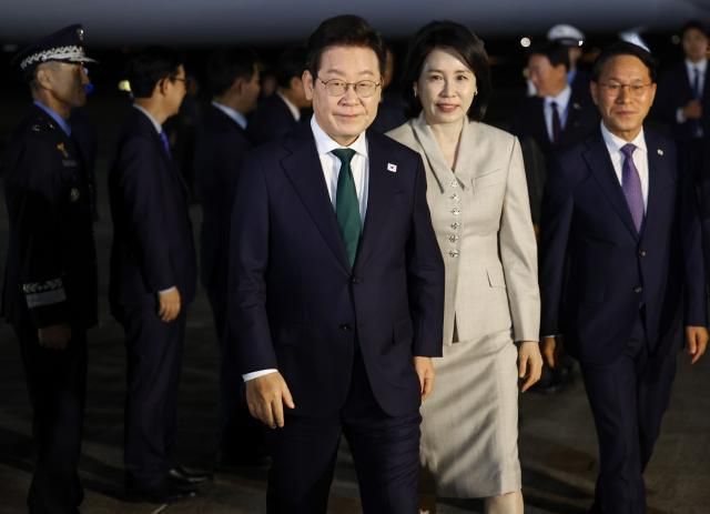 미국 방문 일정을 마치고 귀국한 이재명 대통령과 김혜경 여사가 26일 성남 서울공항에 착륙한 공군 1호기에서 내려 이동하고 있다사진연합뉴스