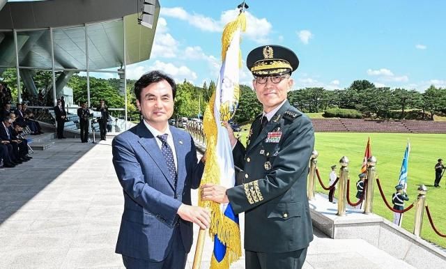 3일 계룡대에서 열린 제52대 육군참모총장 취임식에서 김규하 육군참모총장오른쪽이 안규백 국방부 장관에게서 지휘권을 상징하는 육군기를 인수받고 있다 사진육군 