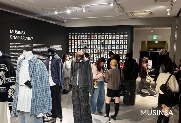 ‘무신사 도쿄 팝업 스토어 2025’ 스냅 아카이브 존을 둘러보는 방문객들 사진무신사