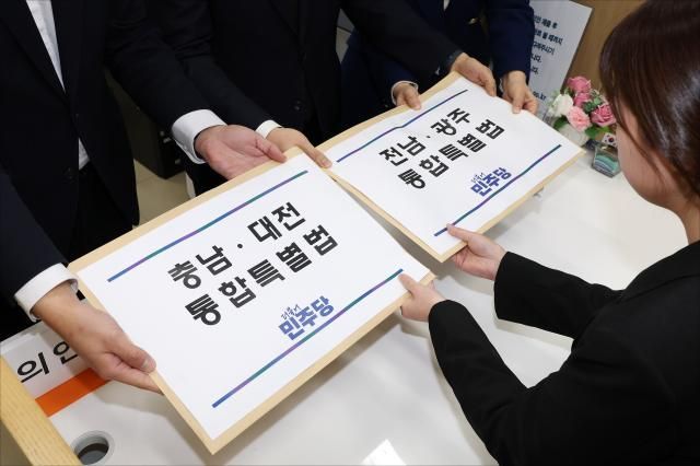 천준호 더불어민주당 원내운영수석부대표가운데 전용기 원내소통수석부대표왼쪽 백승아 원내대변인이 30일 국회 의안과에 충남대전 통합 특별법안과 전남광주 통합 특별법안을 제출하고 있다 사진연합뉴스