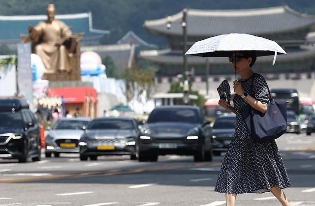 서울 광화문 인근에서 한 시민이 양산을 쓰고 이동하고 있다 사진연합뉴스
