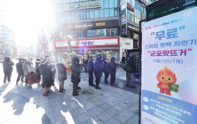 경기도 군포시 산본 로데오거리에 설치된 스마트 핫팩 자판기 군포 핫뜨거에서 시민들이 무료 핫팩을 받기 위해 줄을 서 있다사진연합뉴스 