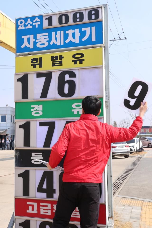 석유 최고가격제 시행 나흘째인 지난 16일 충북 오송의 한 자영 알뜰주유소에서 직원이 휘발유 경우 등 판매 제품의 가격을 낮춰 게시하고 있다 사진연합뉴스