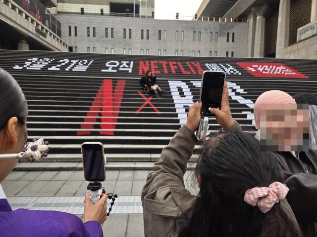 방탄소년단BTS 컴백 공연을 사흘 앞둔 18일 서울 광화문광장을 찾은 팬들이 BTS 새 앨범 홍보 문구로 장식된 세종문화회관 계단에서 기념사진을 촬영하고 있다 사진조재형 기자