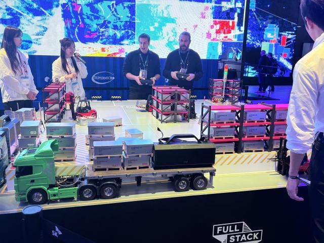 SK텔레콤 부스에서 관람객들이 지게차로 쌓은 풀스택 AI 체험을 하고 있다 사진최연재 기자