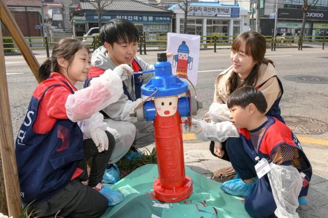 현대모비스 임직원과 가족들이 서울시 도봉구 일대 지상식 소화전 도색 봉사활동을 하고 있는 모습 