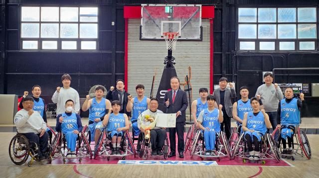 지난 5일 한국휠체어농구연맹 안병태 총재가 코웨이 블루휠스 연습구장을 찾아 김영무 감독에게 표창과 꽃다발을 전달했다 안병태 총재와 김영무 감독 코웨이 블루휠스 선수들이 함께 기념사진을 촬영하고 있다 사진코웨이