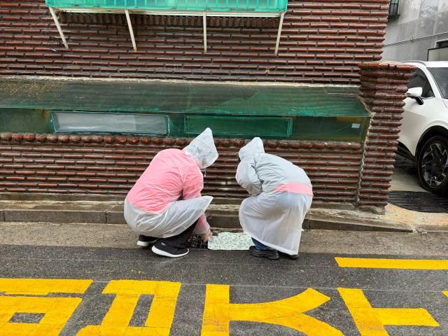 방학2동 모아센터의 마을매니저들이 빗물받이 상태를 점검하고 있다 사진이은별 기자