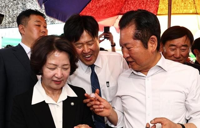 정청래 더불어민주당 대표가 19일 경기도 성남시 모란민속5일장을 방문해 김용 전 민주연구원 부원장에게 사탕을 건네고 있다 사진연합뉴스