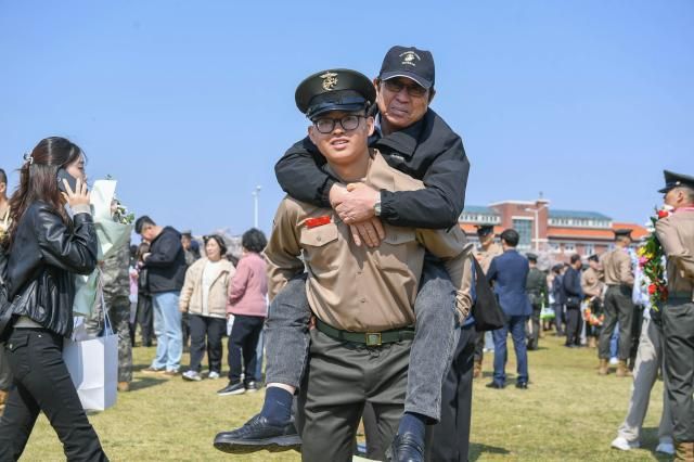 2일 해병대 교육훈련단 행사연병장에서 열린 해병대 신병 1327기 수료식에서 해병대 최초 4대 해병 가족이 된 김준영 이병이 2대 해병인 할아버지를 업고 기념 촬영하고 있다 사진해병대사령부 