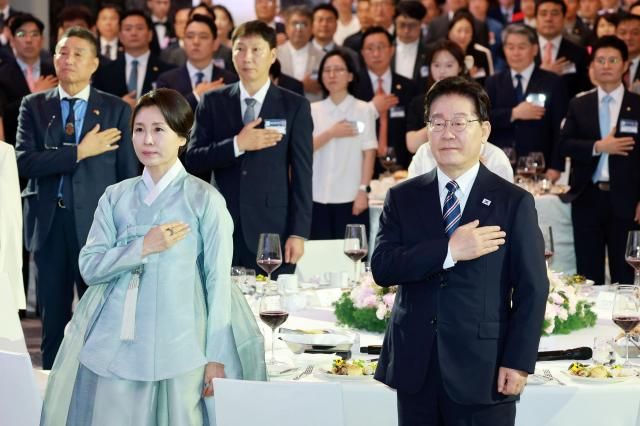 베트남을 국빈 방문 중인 이재명 대통령과 김혜경 여사가 22일현지시간 하노이의 한 호텔에서 열린 동포간담회에서 국기에 경례하고 있다 사진연합뉴스