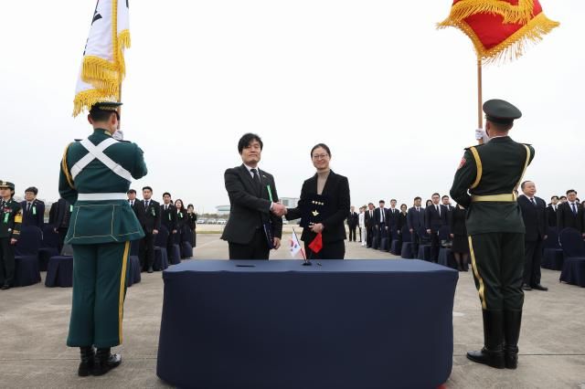 22일 오전 인천국제공항에서 개최된 제13차 중국군 유해송환 인도식 행사에서 유해 인수인계 서명식을 마치고 이광석 국방부 국제정책관왼쪽과 스이 중국 국제협력사 부사장오른쪽이 악수를 나누고 있다 사진국방부