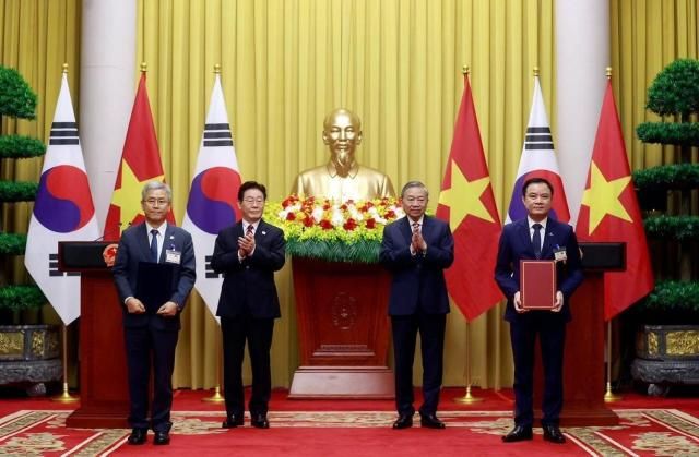 김동철 한국전력 사장이 레 응옥 손 베트남 국가산업에너지공사 회장과 양국 정상이 배석한 가훈데 원전 개발 협력 가능성 검토 업무협약MOU를 체결한 뒤 기념 촬영을 하고 있다사진한국전력