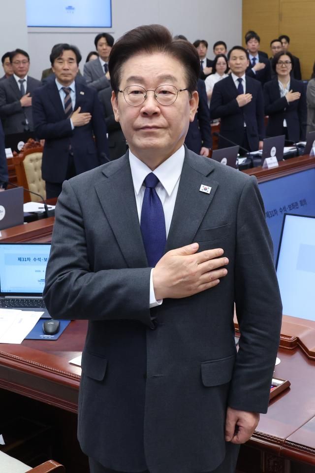 이재명 대통령이 30일 청와대에서 열린 수석보좌관회의에서 국기에 경례를 하고 있다 사진연합뉴스