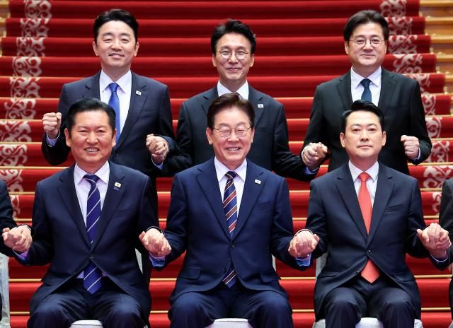 이재명 대통령이 7일 청와대에서 여야정 민생경제 협의체 회담에 앞서 더불어민주당 정청래 대표 국민의힘 장동혁 대표의 손을 잡고 기념촬영을 하고 있다 뒷줄은 왼쪽부터 강훈식 대통령비서실장 김민석 국무총리 홍익표 정무수석 사진연합뉴스