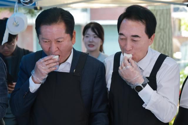 정청래 더불어민주당 대표왼쪽와 박수현 민주당 충남도지사 후보가 1일 충남 서산시 문화회관에서 음식을 준비하던 중 떡을 맛보고 있다 사진연합뉴스