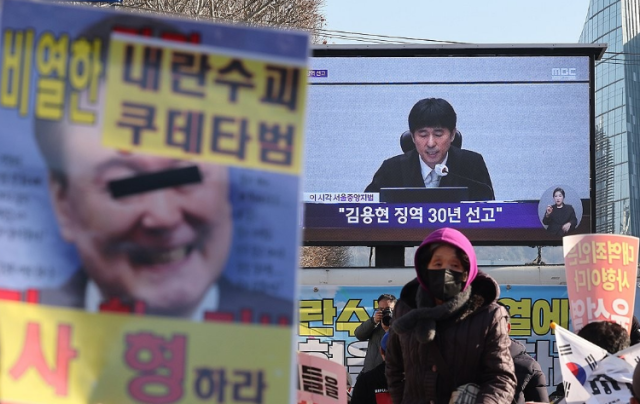 촛불행동 관계자들이 지난 2월 19일 서울 서초구 서울중앙지법 인근에서 12·3 비상계엄과 관련해 내란 우두머리 혐의로 기소된 김용현 전 국방부 장관에 대한 1심 선고 생중계를 시청하고 있다 사진연합뉴스