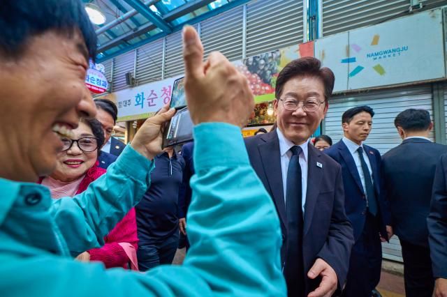 이재명 대통령과 김혜경 여사가 18일 광주 동구 남광주시장을 찾아 시민들과 인사하고 있다 사진연합뉴스